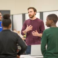 high school students interacting with a project